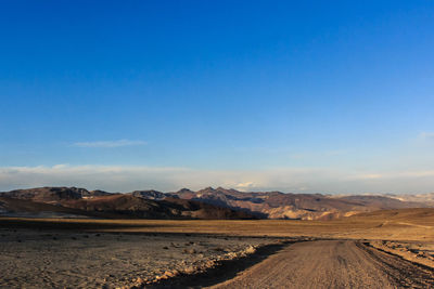 Scenic view of desert against blue sky