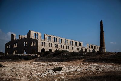 Low angle view of old ruin against blue sky