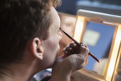 Young man applying drag makeup