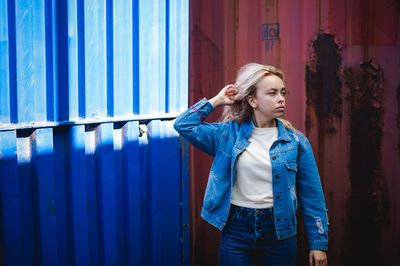 Woman standing against cargo container