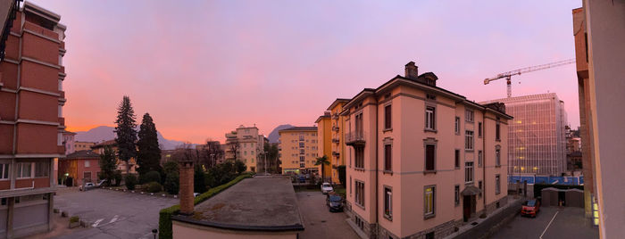 Street amidst buildings against sky during sunset