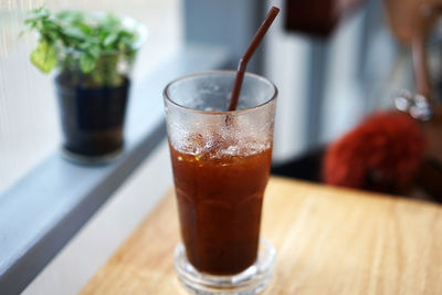 Close up glass of iced black coffee on wooden table