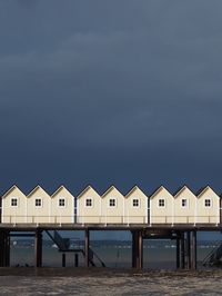 Beach huts by sea against sky