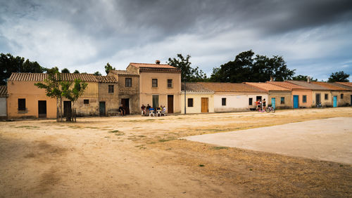 Houses by street and buildings against sky