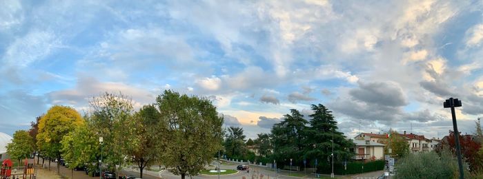 Panoramic shot of trees and buildings against sky