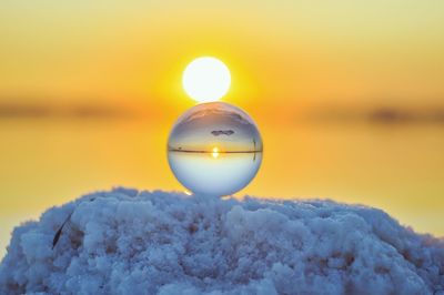 Close-up of frozen sea against sky during sunset