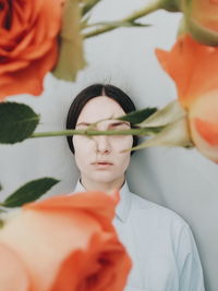 Young woman with roses against wall