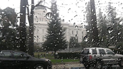 Cars on road seen through wet window