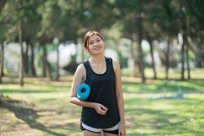 Smiling young woman standing against blurred background