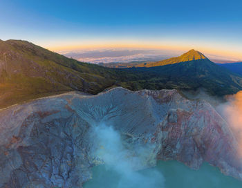 Panoramic view of volcanic mountain against sky during sunset