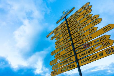 Low angle view of sign board against cloudy sky