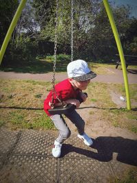 Full length of boy on swing at playground