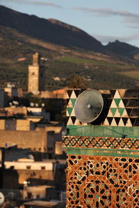 Megaphone on mosque against buildings at dusk
