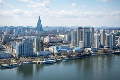 River amidst buildings in city against sky