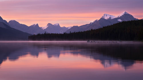 Scenic view of lake and mountains against sky during sunset