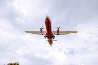 Low angle view of airplane flying against sky