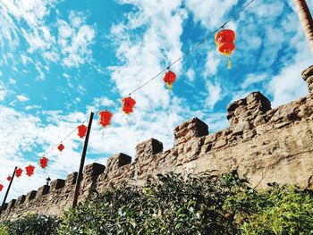 Low angle view of flags on mountain against sky