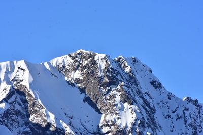 Scenic view of snowcapped mountains against clear blue sky