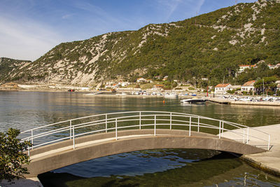 Scenic view of sea by mountains against sky