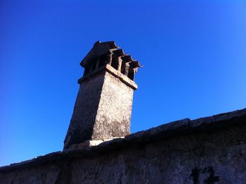 Low angle view of clock tower against blue sky