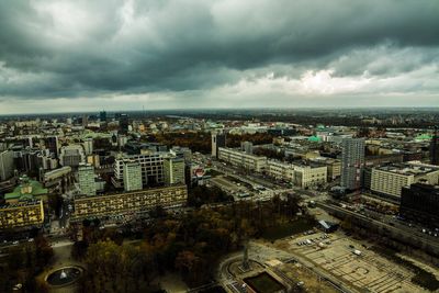 Aerial view of cityscape against storm clouds