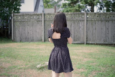 Rear view of woman wearing hat on field