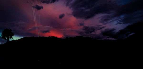 Low angle view of silhouette mountain against dramatic sky