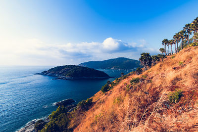 Scenic view of sea and mountains against blue sky