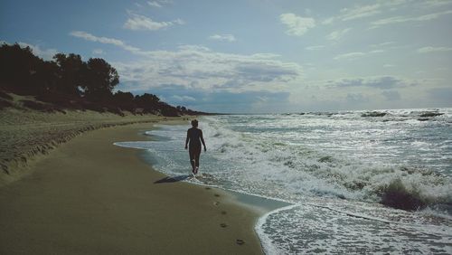 Rear view of man standing on beach