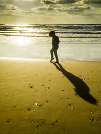 Full length of man standing on beach against sky