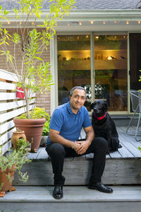 Full length of man sitting with dog