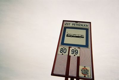 Close-up of information sign against sky