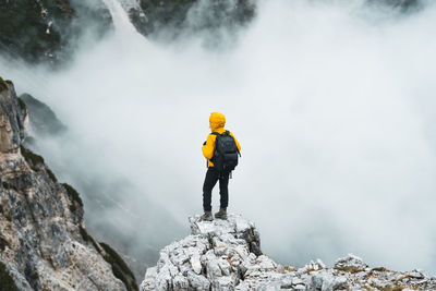 Rear view of man standing on rock