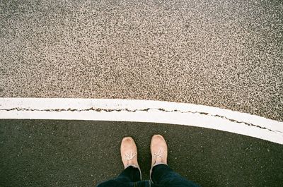 Low section of man standing on road