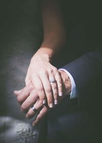 Midsection of bride holding groom hand