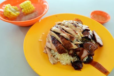 Close-up of chicken with rice in plate by sweetcorn