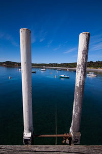 Wooden post in lake against sky