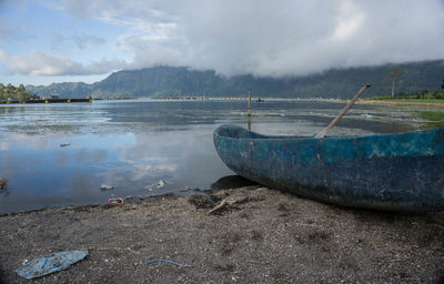 Fishing net in sea against cloudy sky