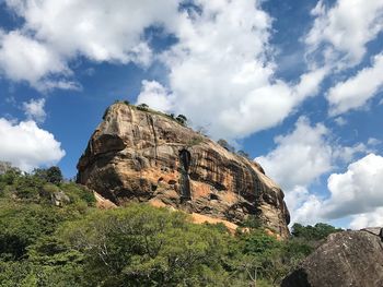 Low angle view of rocks on mountain against sky