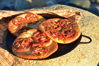 High angle view of tomato focaccia bread on metal plate on table