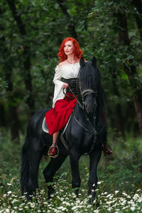 Full length of woman riding horse