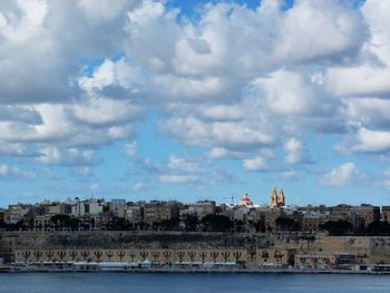 Buildings in city against cloudy sky