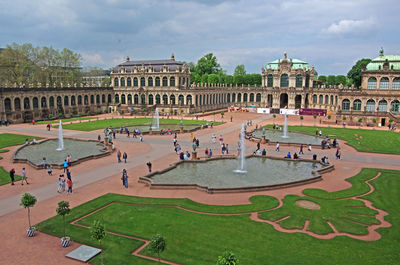 Fountain at historic building against cloudy sky