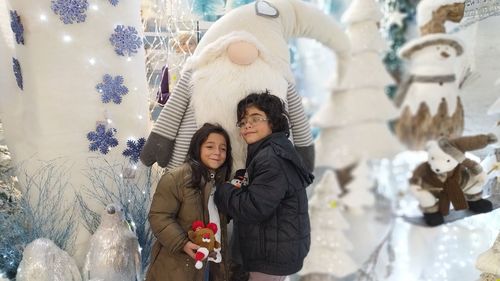 Siblings embracing stuffed sculpture