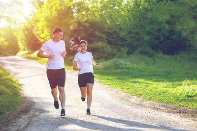 Rear view of friends running on road