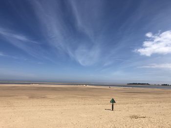 Man standing on beach against blue sky