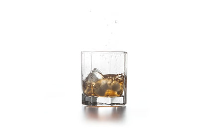 Close-up of drink served on glass against white background