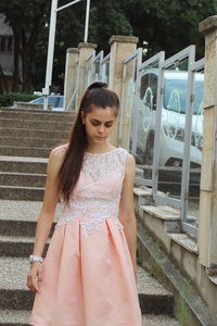 Young woman looking up while standing outdoors