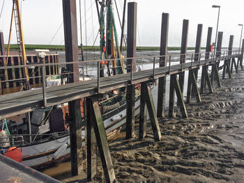 Wooden posts on beach against sky