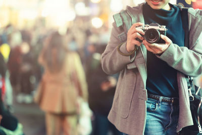 Midsection of woman photographing outdoors